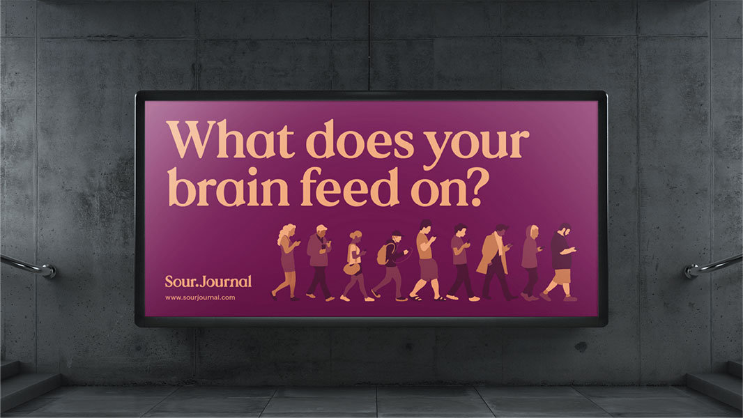 A large, rectangular digital display screen mounted on a gray concrete wall shows a graphic with the question "What does your brain feed on?" in white text on a purple background. Below the text, the Sour.Journal logo and website address (www.sourjournal.com) are visible in white text. Below the screen, a row of stylized figures in muted brown and beige colors walk from left to right, appearing to walk in a line. The scene is set in a dimly lit environment with visible concrete wall and floor elements.