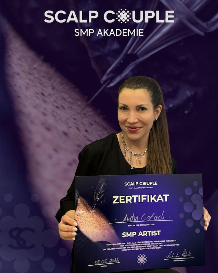 Audra Gstach hält ihr Zertifikat als SMP Artist der Scalp Couple Akademie, Mai 2026