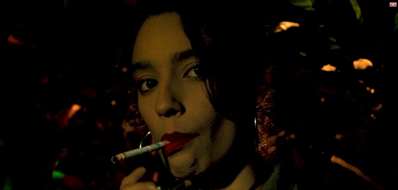 View of the French countryside through a stone villa’s open living room, with sofas and trees framing the scene