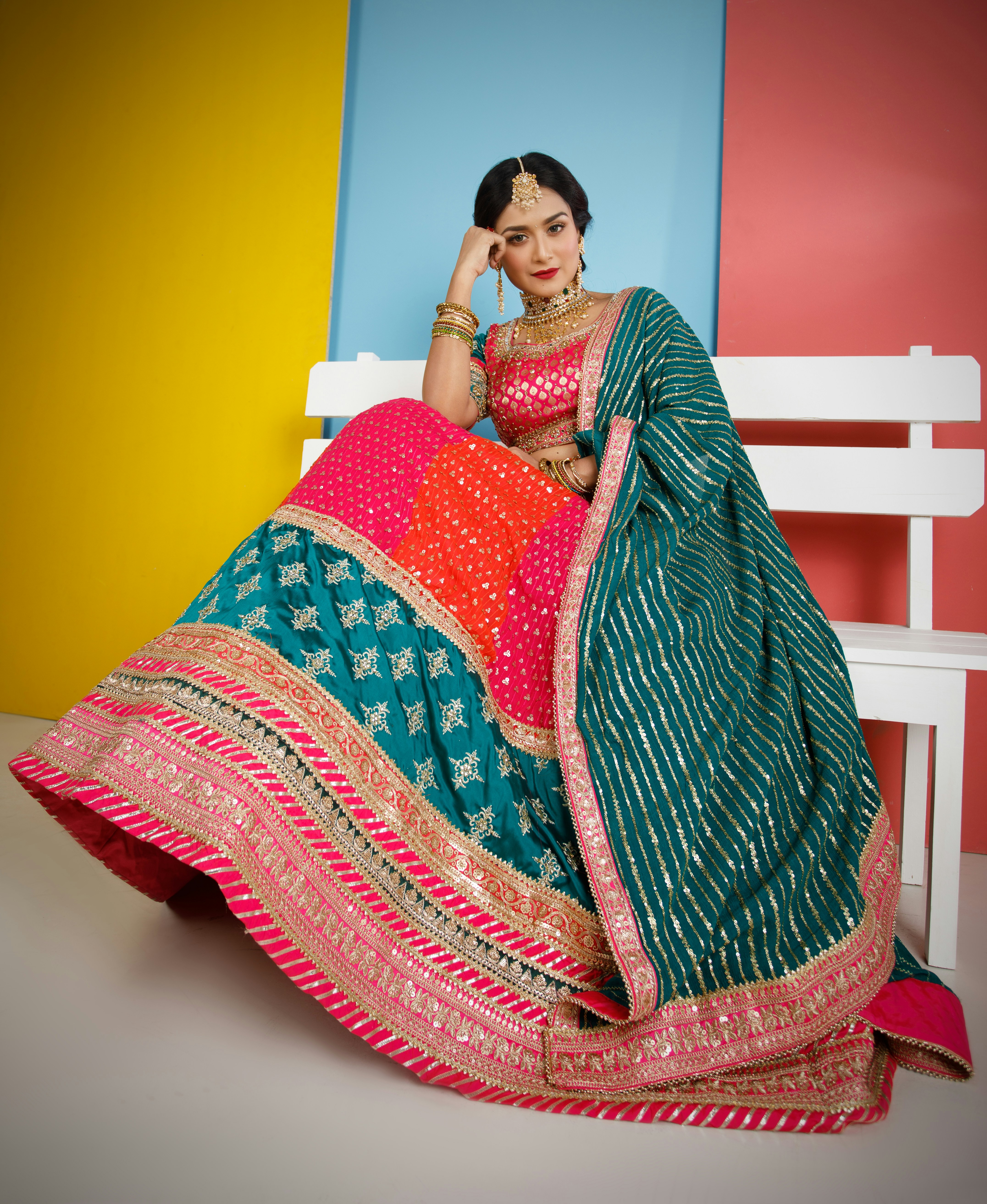 a woman sitting on a bench in a colorful dress