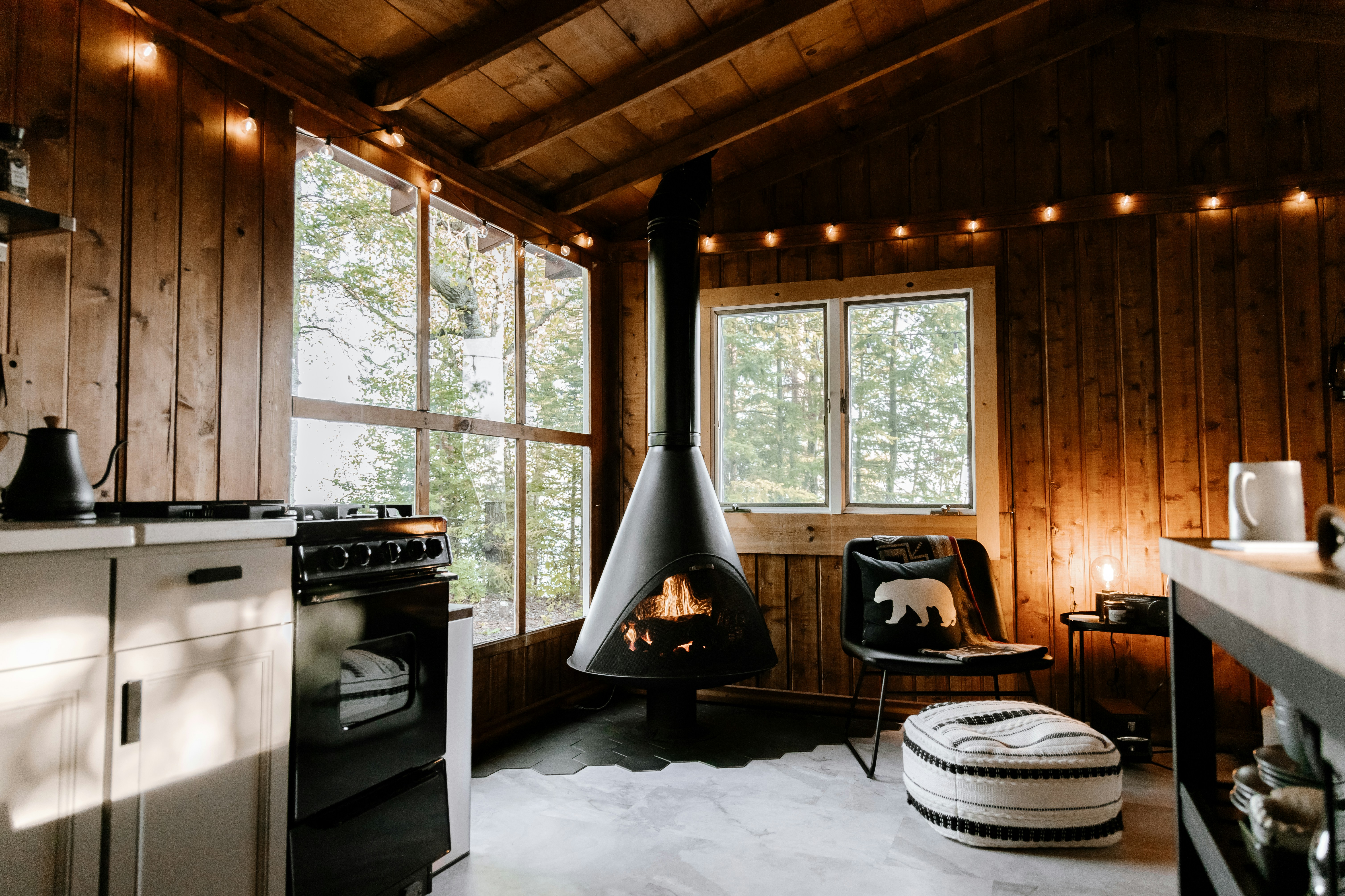 Rustic cabin interior with exposed wood beams and a fireplace.