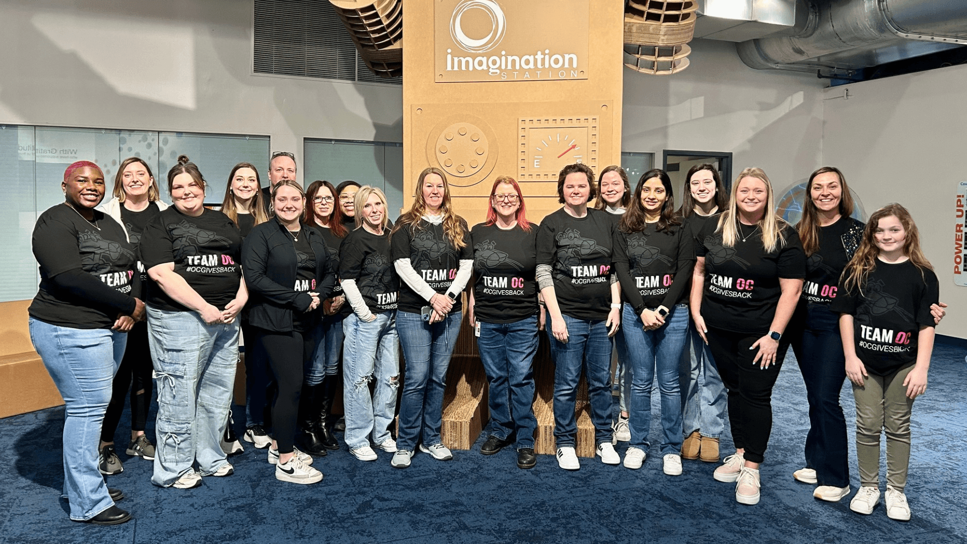 A group of volunteers stand and smile.