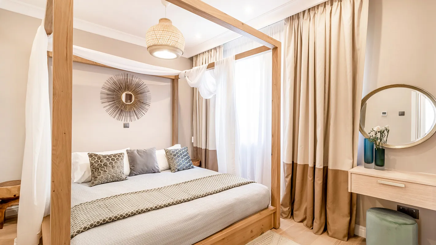 White Cedar House Mediterranean bedroom with timber four-poster bed, woven pendant light, and vanity corner