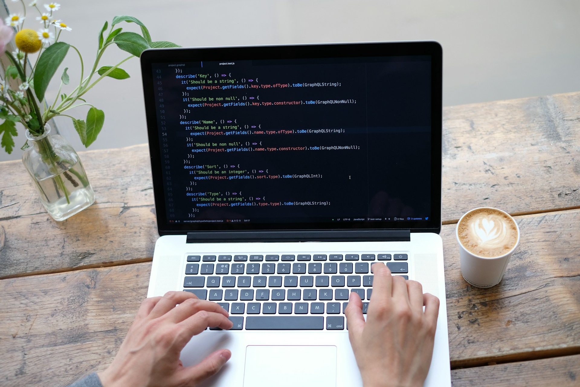 a person sitting behind a laptop coding