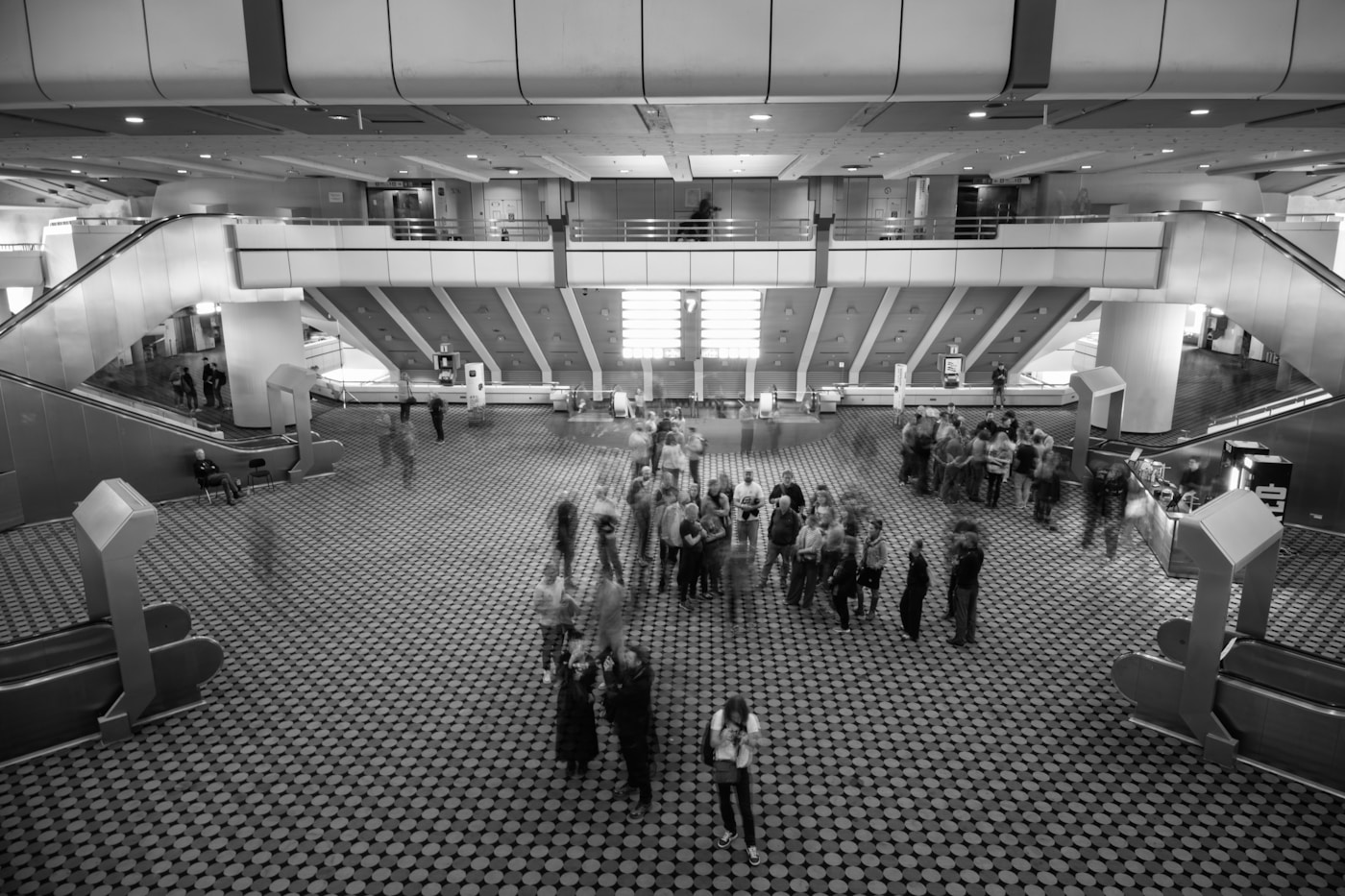People gathered in a large modern atrium with escalators