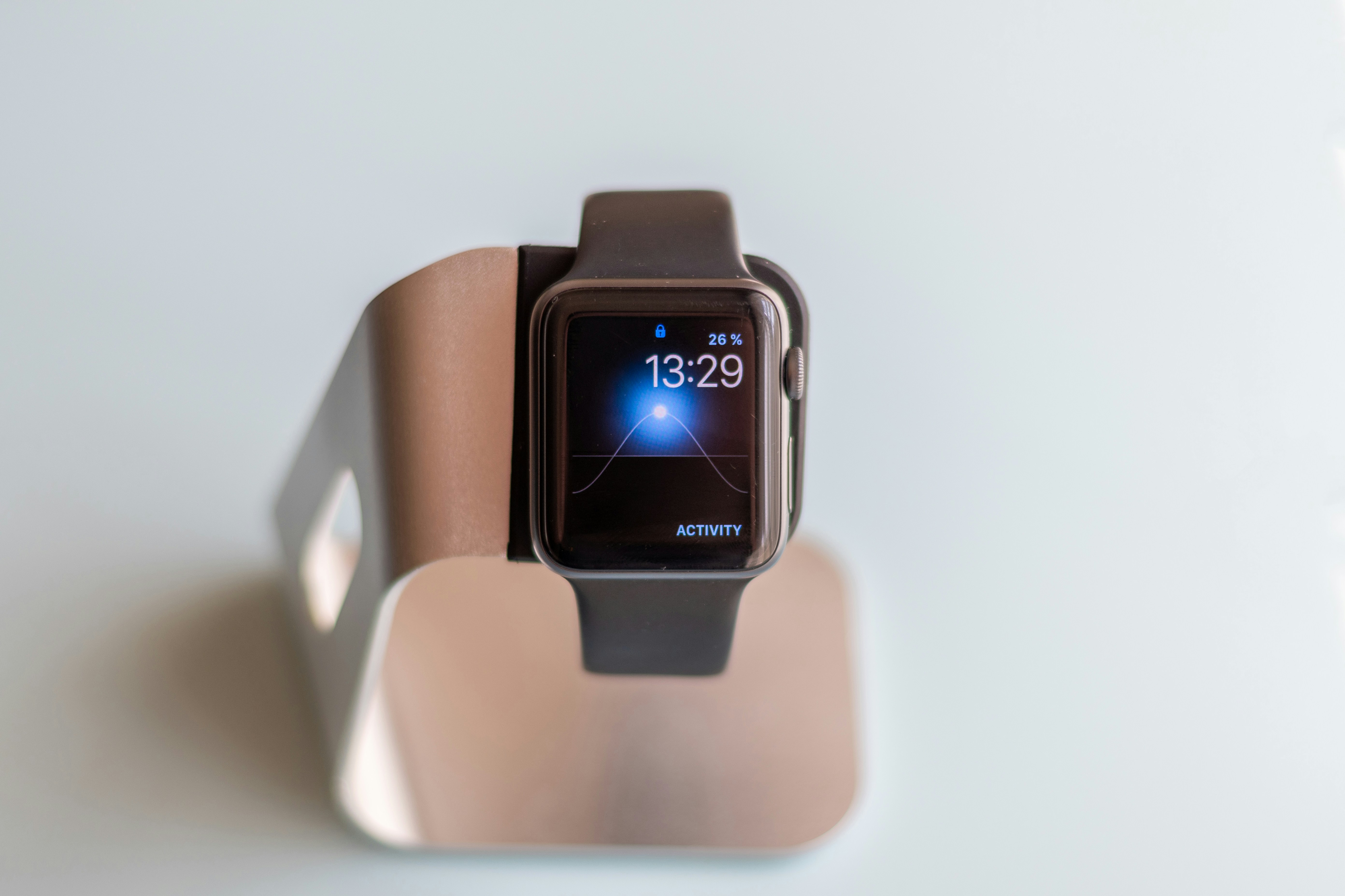 Apple Watch resting on a minimalist charging dock against a clean white background