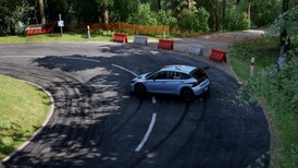 Voiture de rallye en drift dans un virage serré sur route asphaltée, traces de pneus et forêt dense – Assetto Corsa Rally PC Steam.