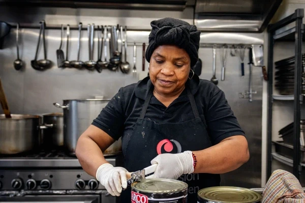 Soup Kitchen volunteer opening cans in the kitchen