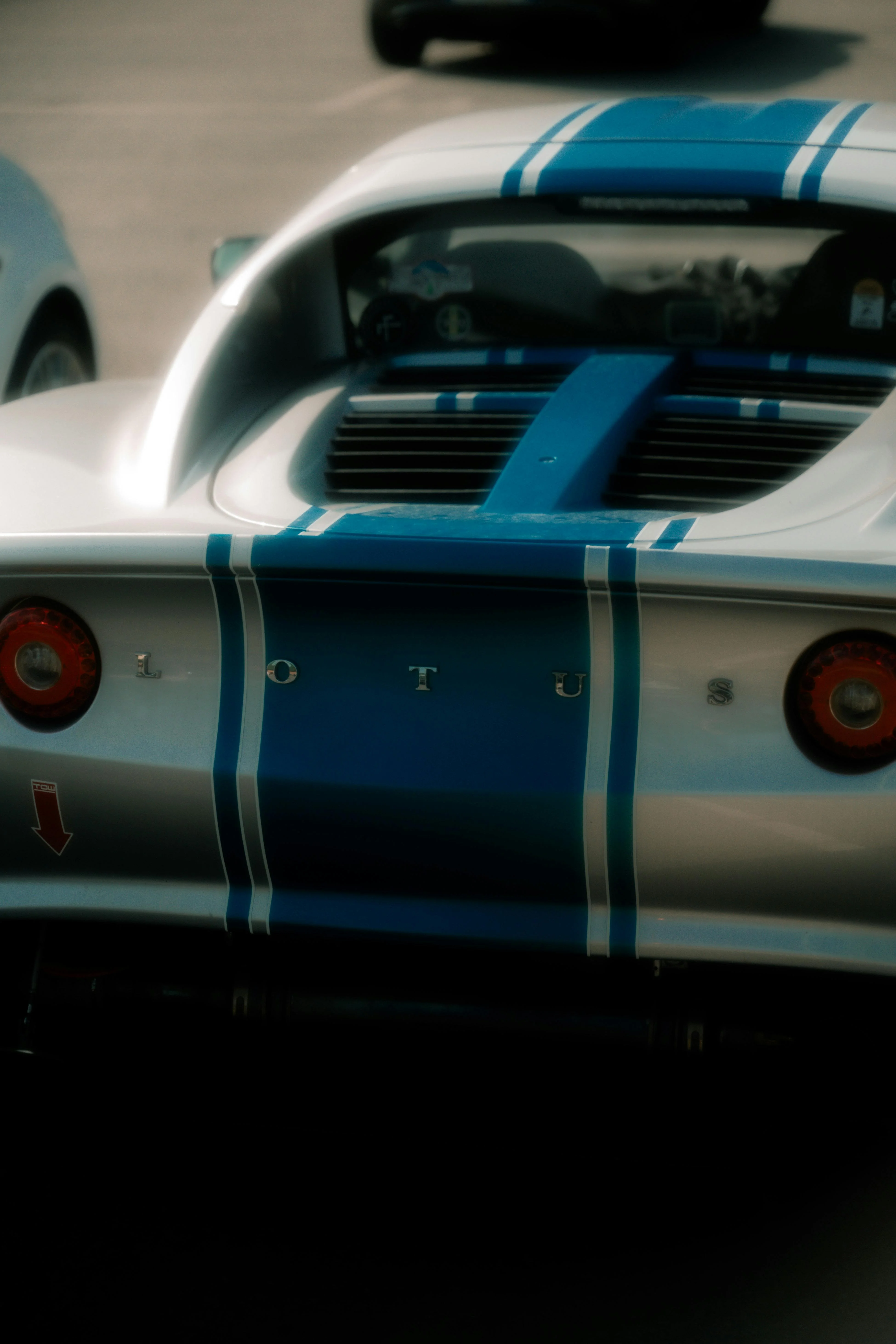 Une Lotus argentée ornée de bandes bleues, symbole du design sportif et de la philosophie de légèreté chère à la marque britannique.