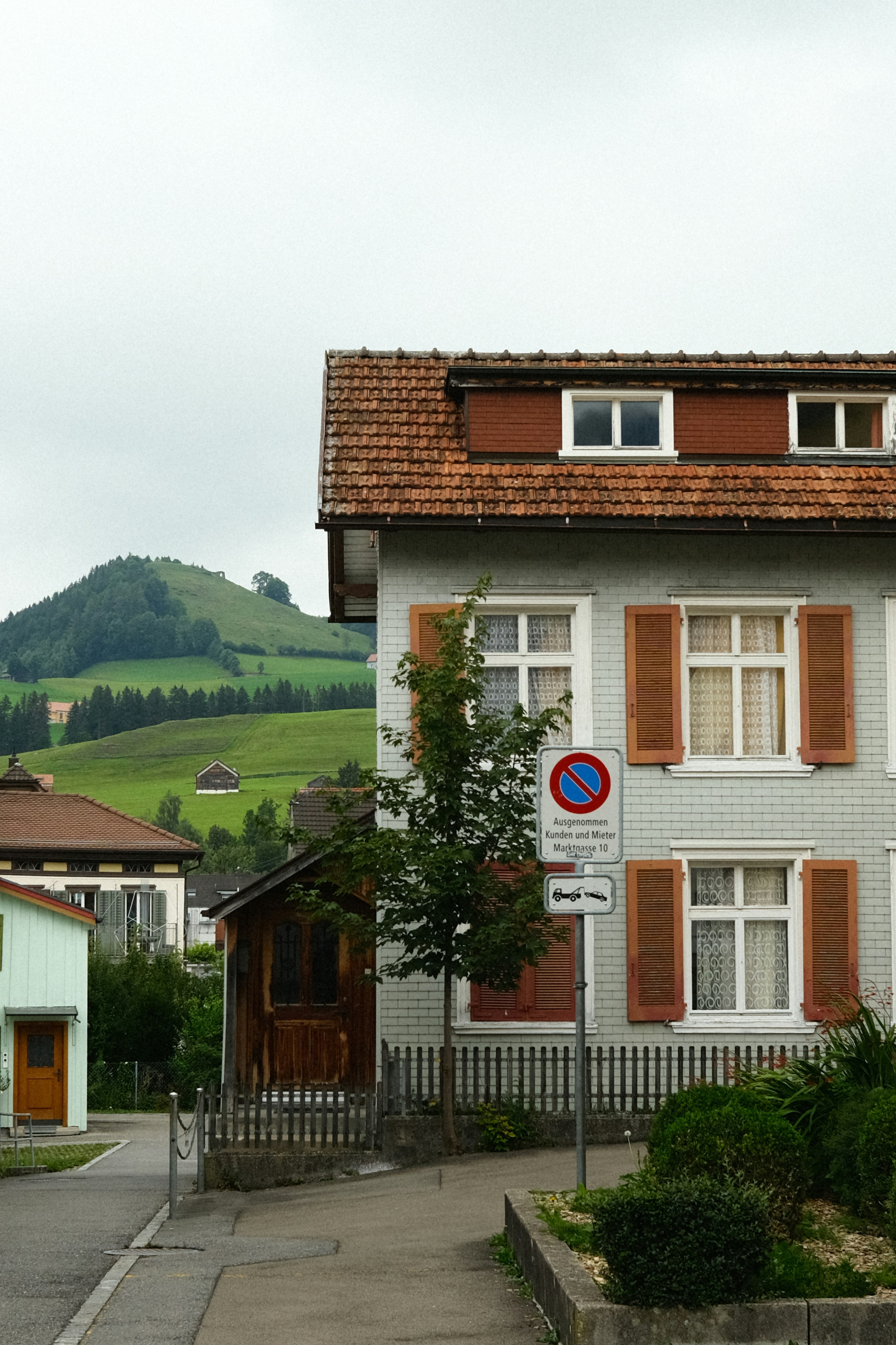 A white house with brown shutters on a street corner