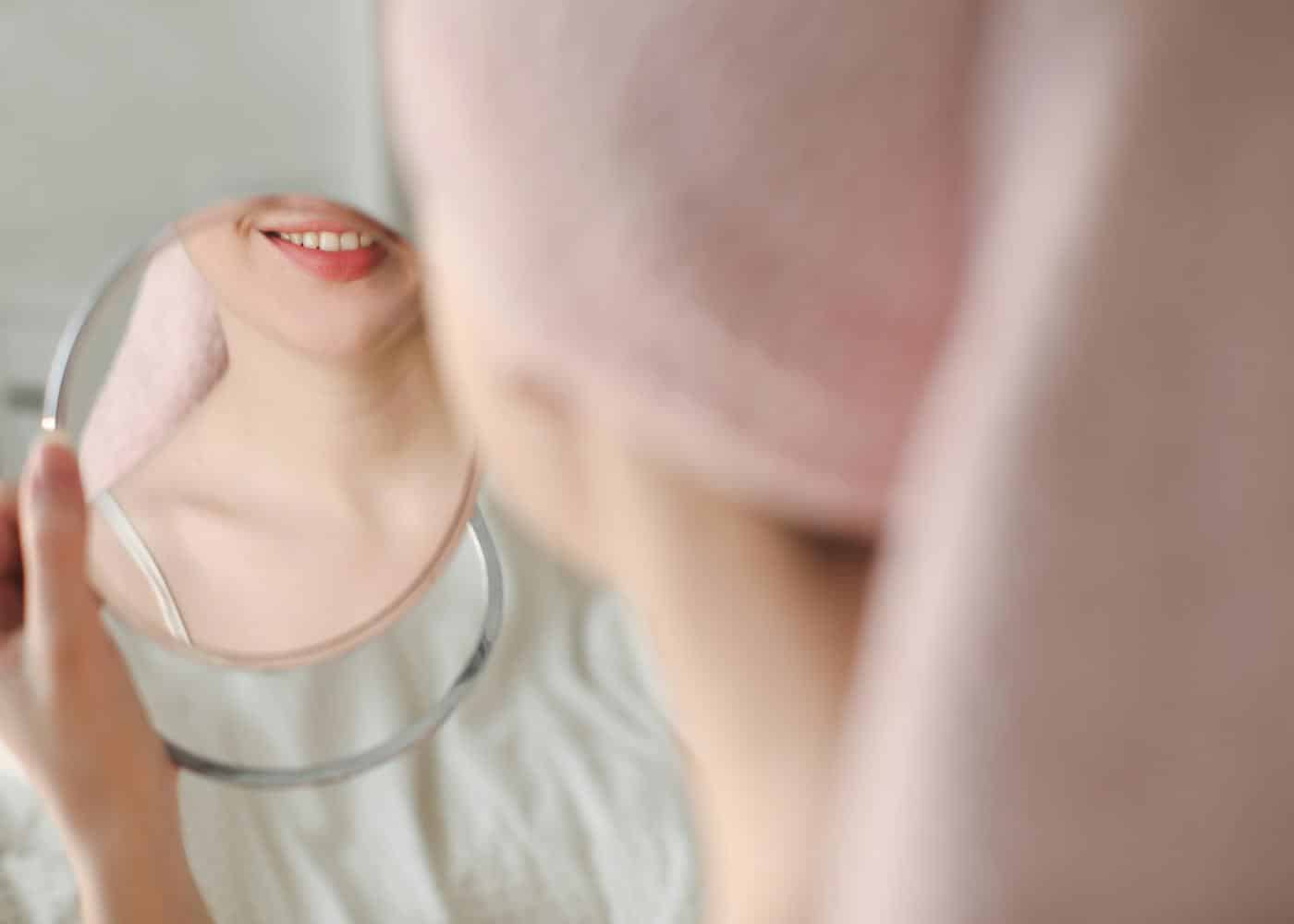 Oral Hygiene Diet - Woman checking her smile in a mirror