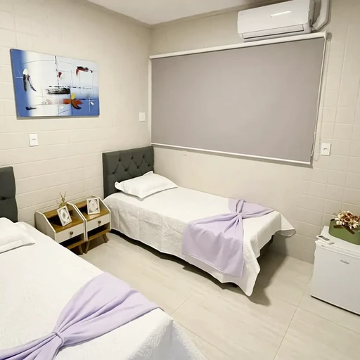 Quarto adaptado para idosos, com barras de segurança, iluminação natural e ambiente humanizado.