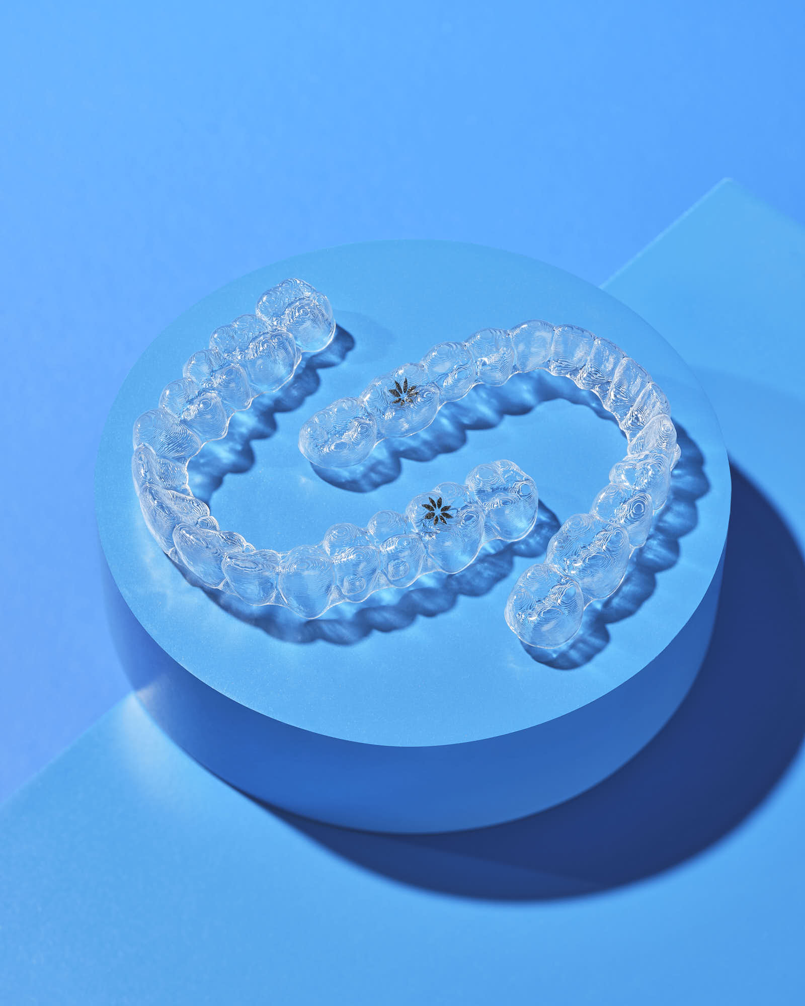 Clear dental aligners on a blue background.