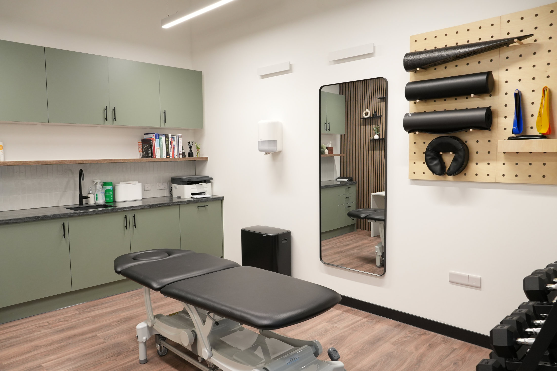 A modern physiotherapy studio with treatment bed and exercise equipment