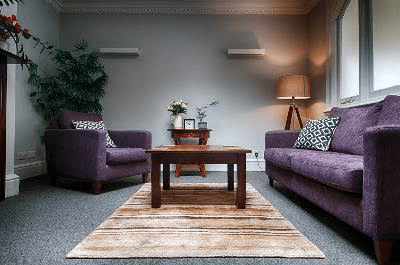 a woman sitting on a couch talking to another woman