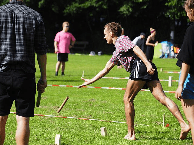 Mann wirft einen Holzstab