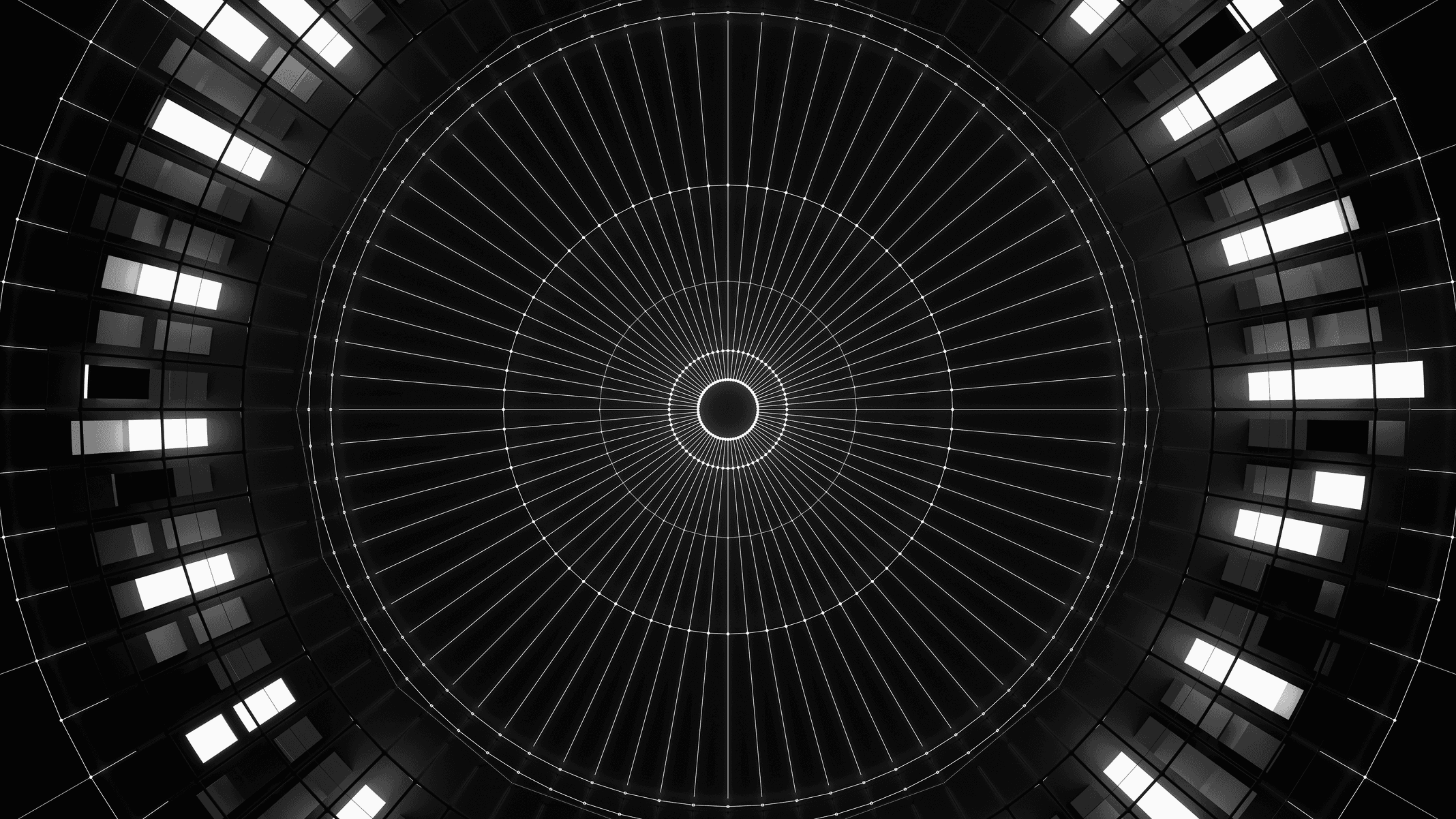 Looking up through a circular architectural structure, concentric rings of light converging toward a central point, black and white.