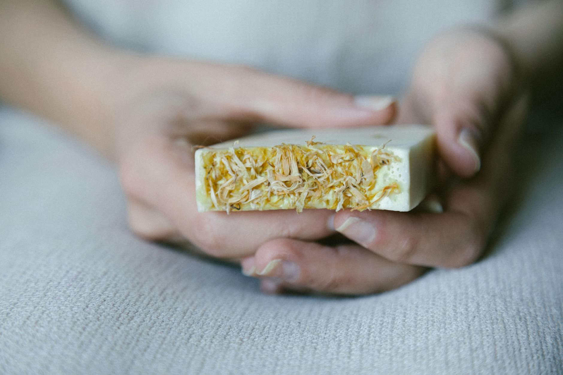 Close-up of hands holding eco-friendly handmade soap with natural extracts.
