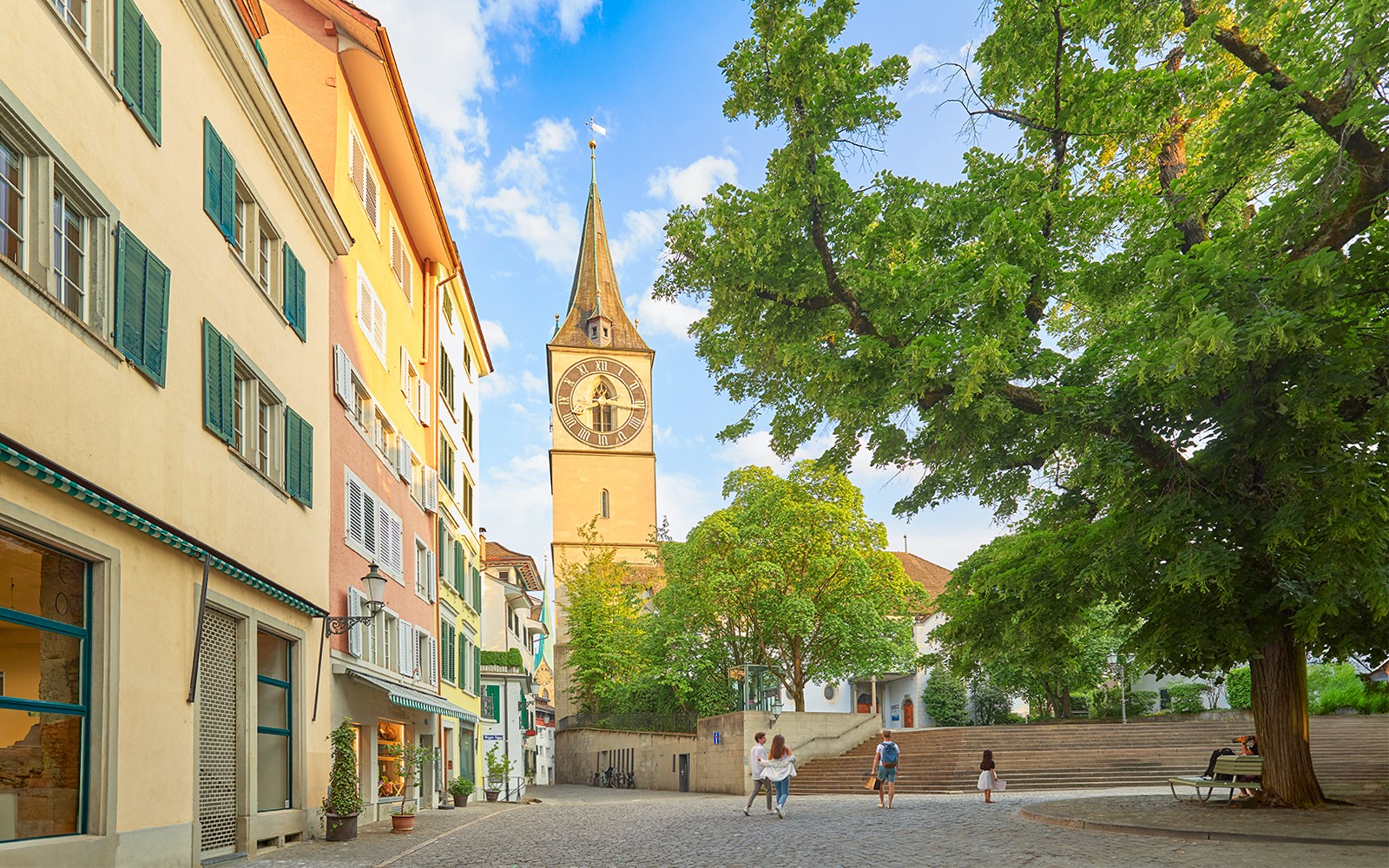 Zürichs stadstorg med Peterskyrkans torn och färgglada byggnader.