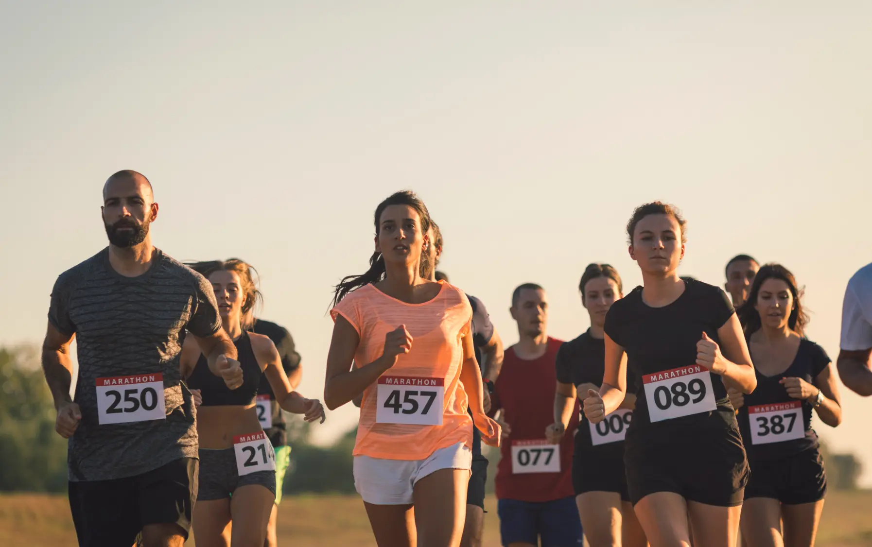 Group of marathon runners competing in an outdoor race representing perseverance and grit
