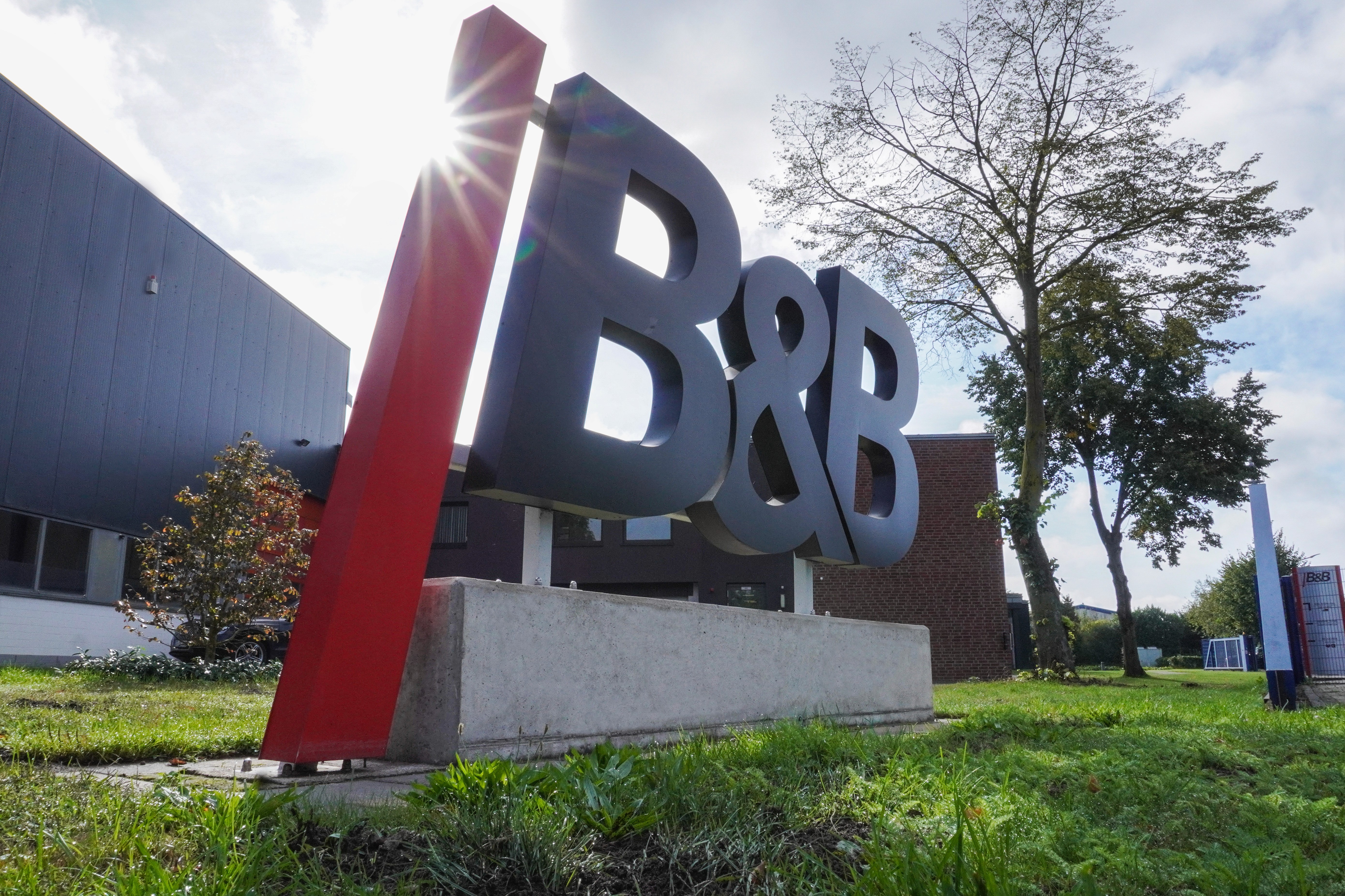 B&B Logo vor Gebäude, Sonne, Firmenschild