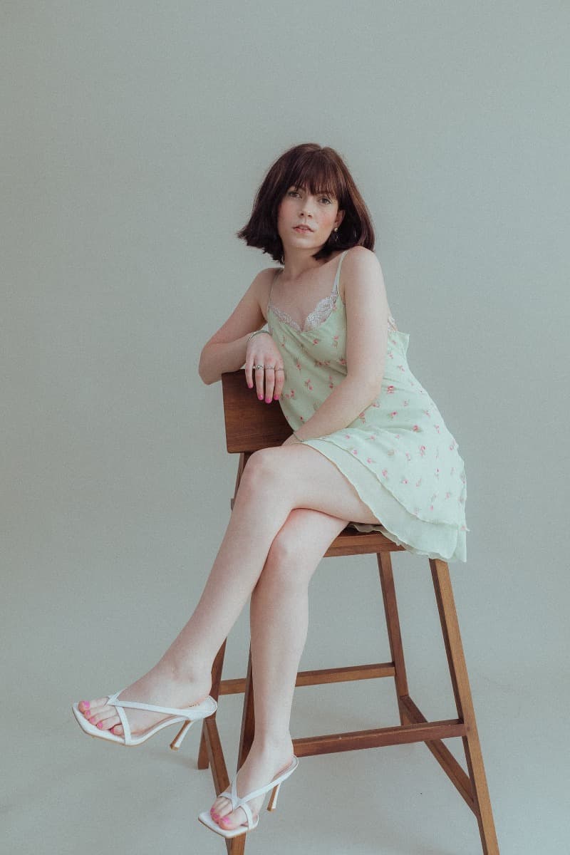 A model sits elegantly on a chair during a session at Revelator Studio, highlighting the studio’s natural light and minimalist aesthetic in Shreveport