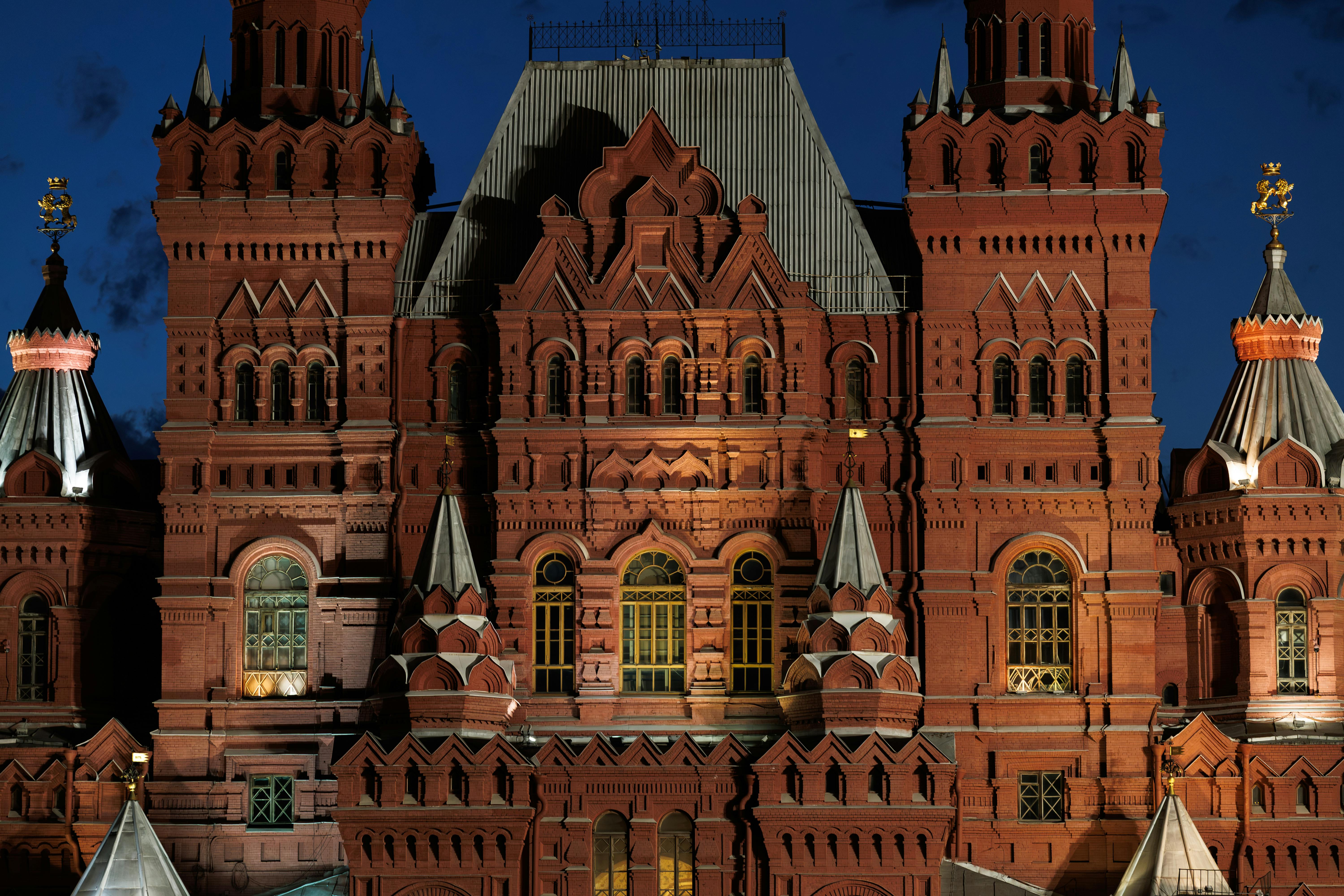 red train travelling near body of water