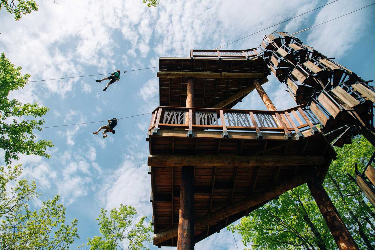 Zipliners taking off from a 6 story dual zipline