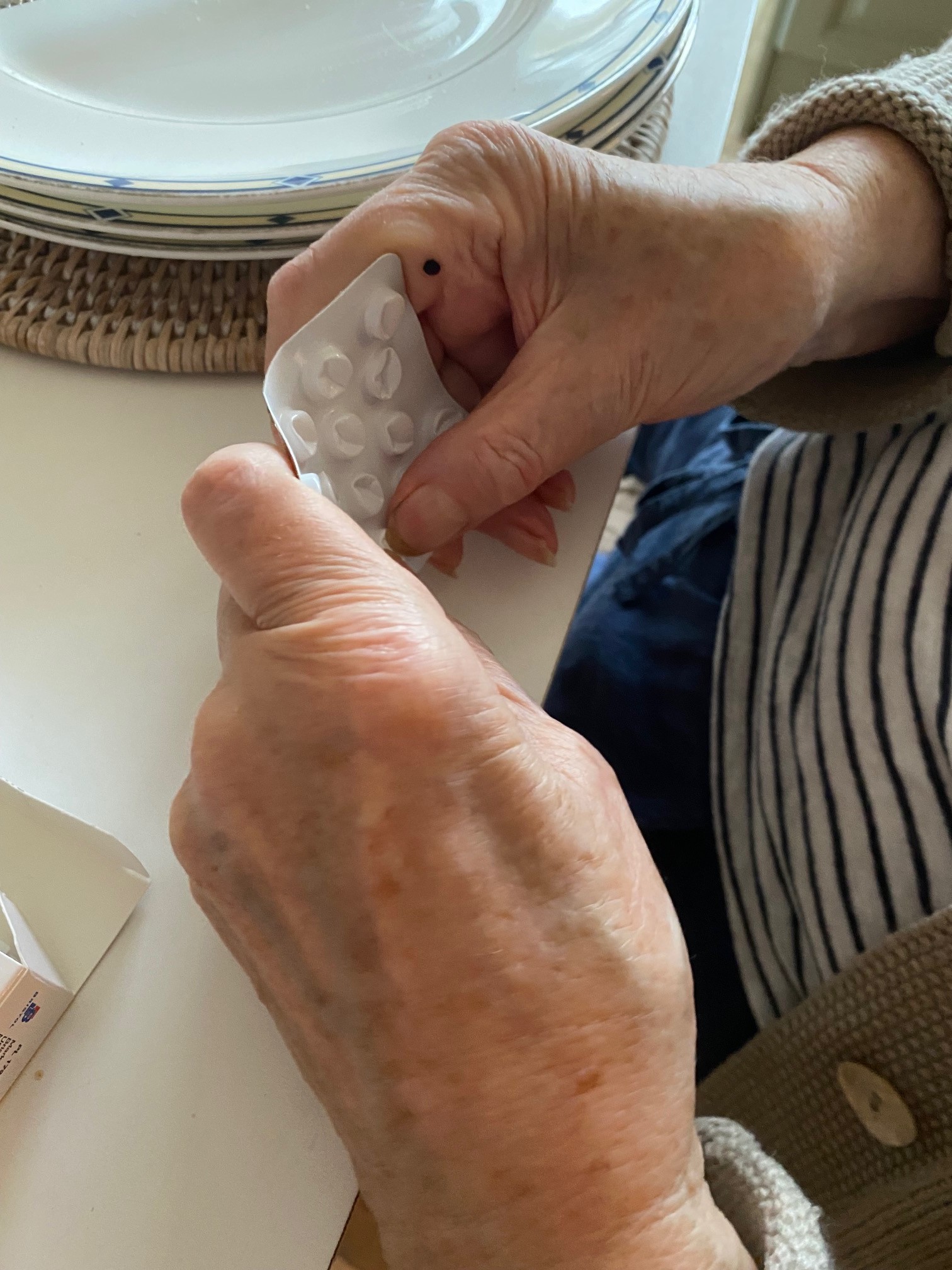 Elderly person opening pill packet 5.