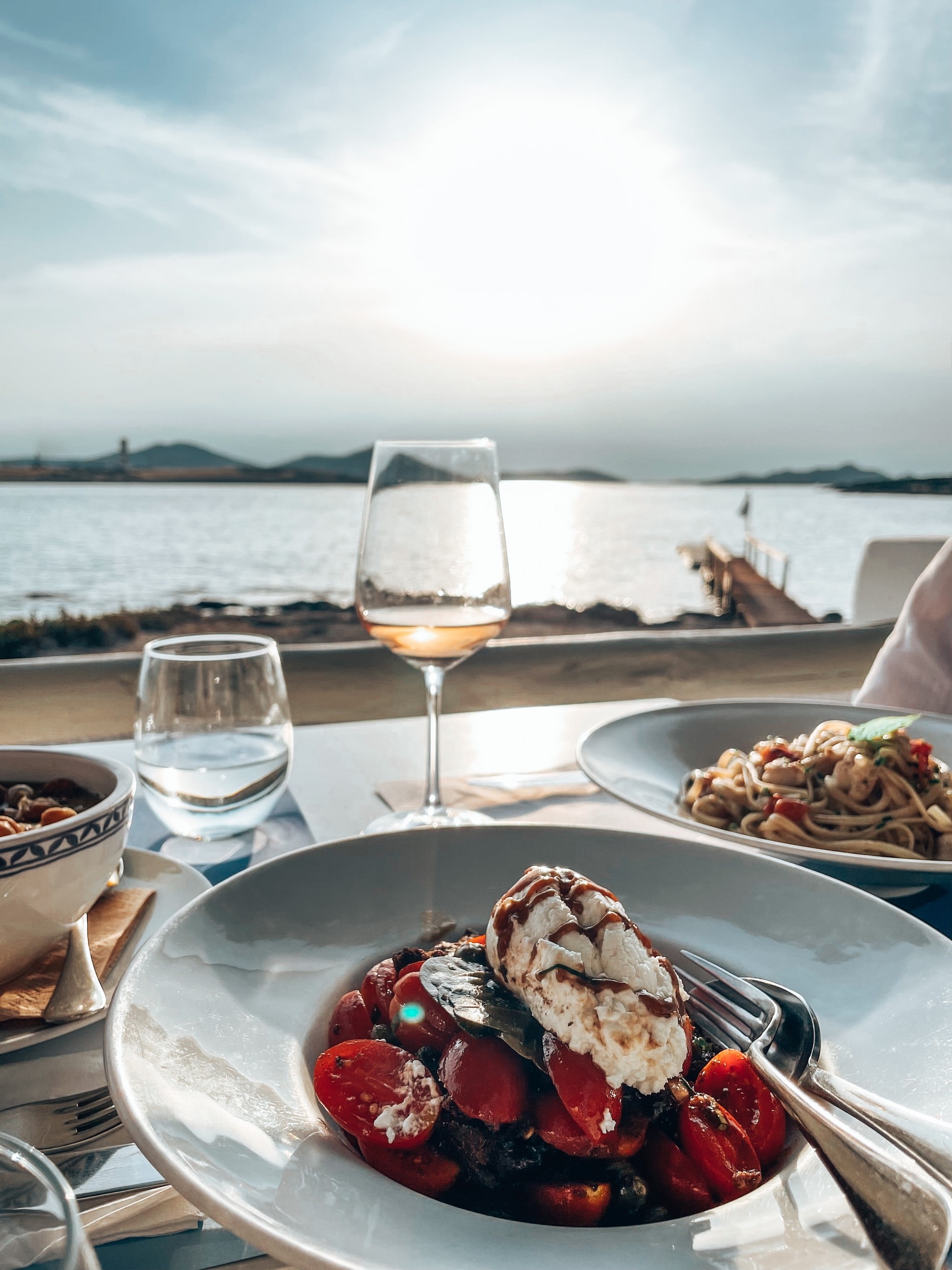 Lovely greek dinner by the sea. A glass of wine and the sun setting
