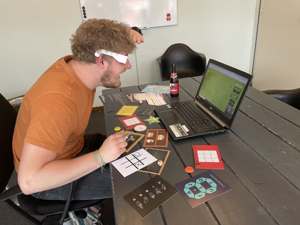 Deelnemer lost opdrachten op achter zijn laptop tijdens een online teambuildingactiviteit van The Box Company.  