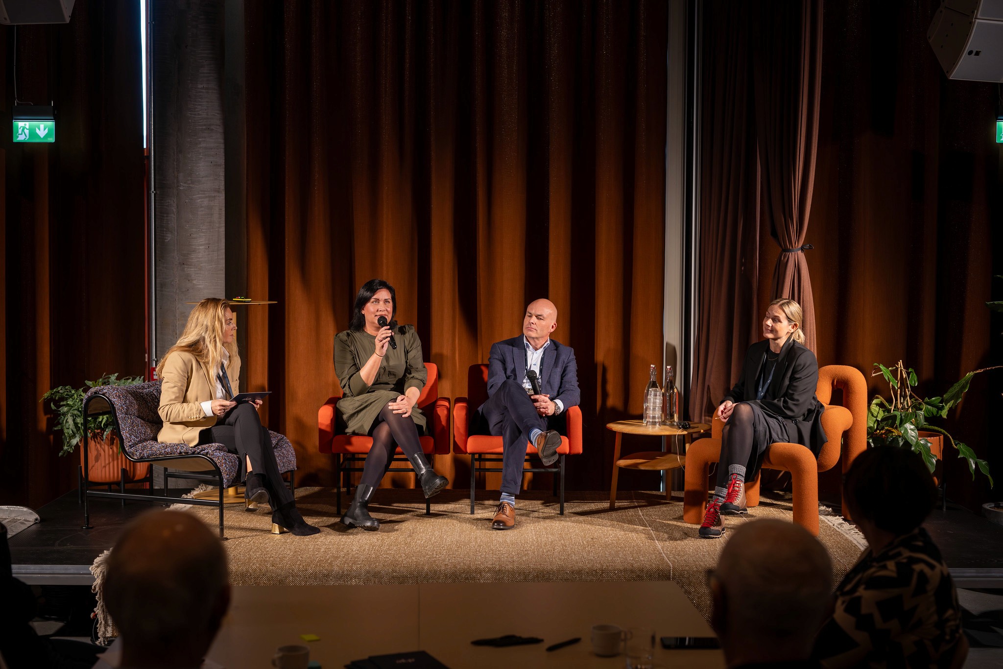 A group of people mingling at an event, with one man looking upwards, appearing deep in thought.