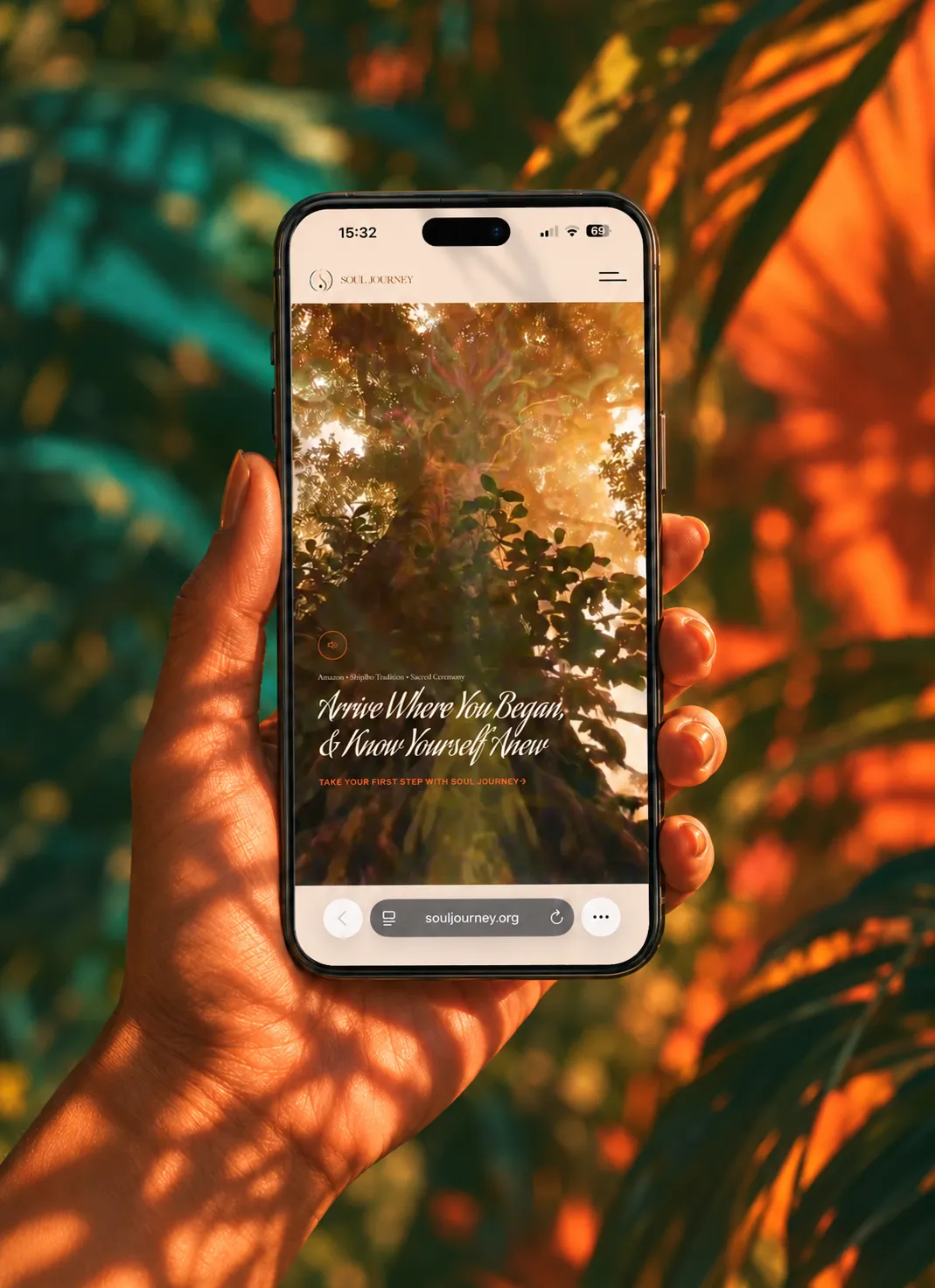 Hand holding an iPhone displaying the Soul Journey retreat website in warm jungle-inspired light