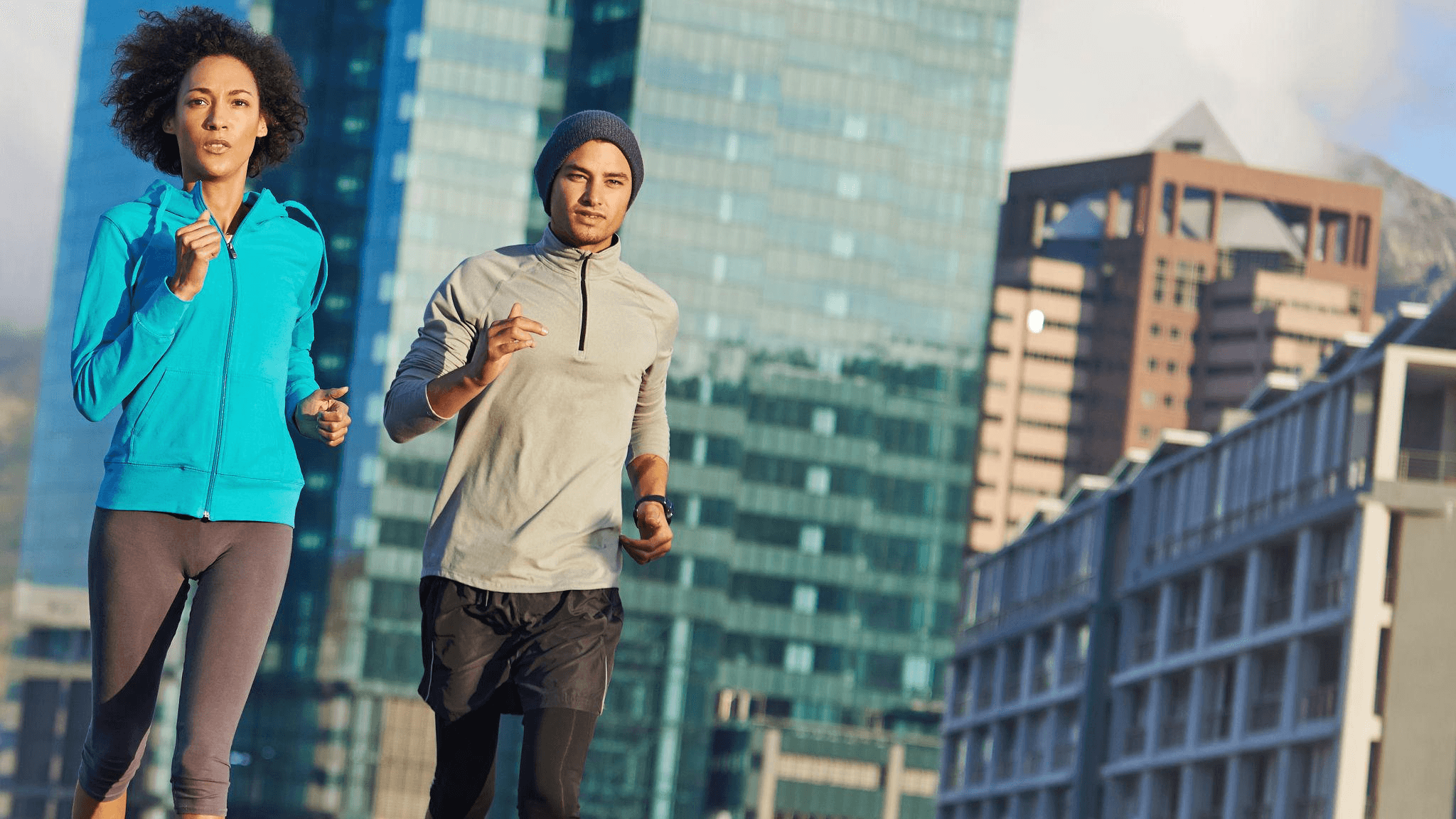 Four diverse professionals collaboratively working on a laptop, with one person pointing at the screen while others observe.