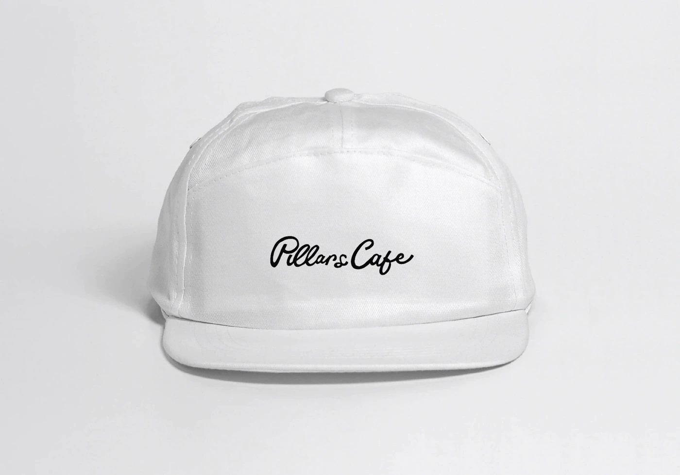 White Pillars Cafe cap with black script logo.