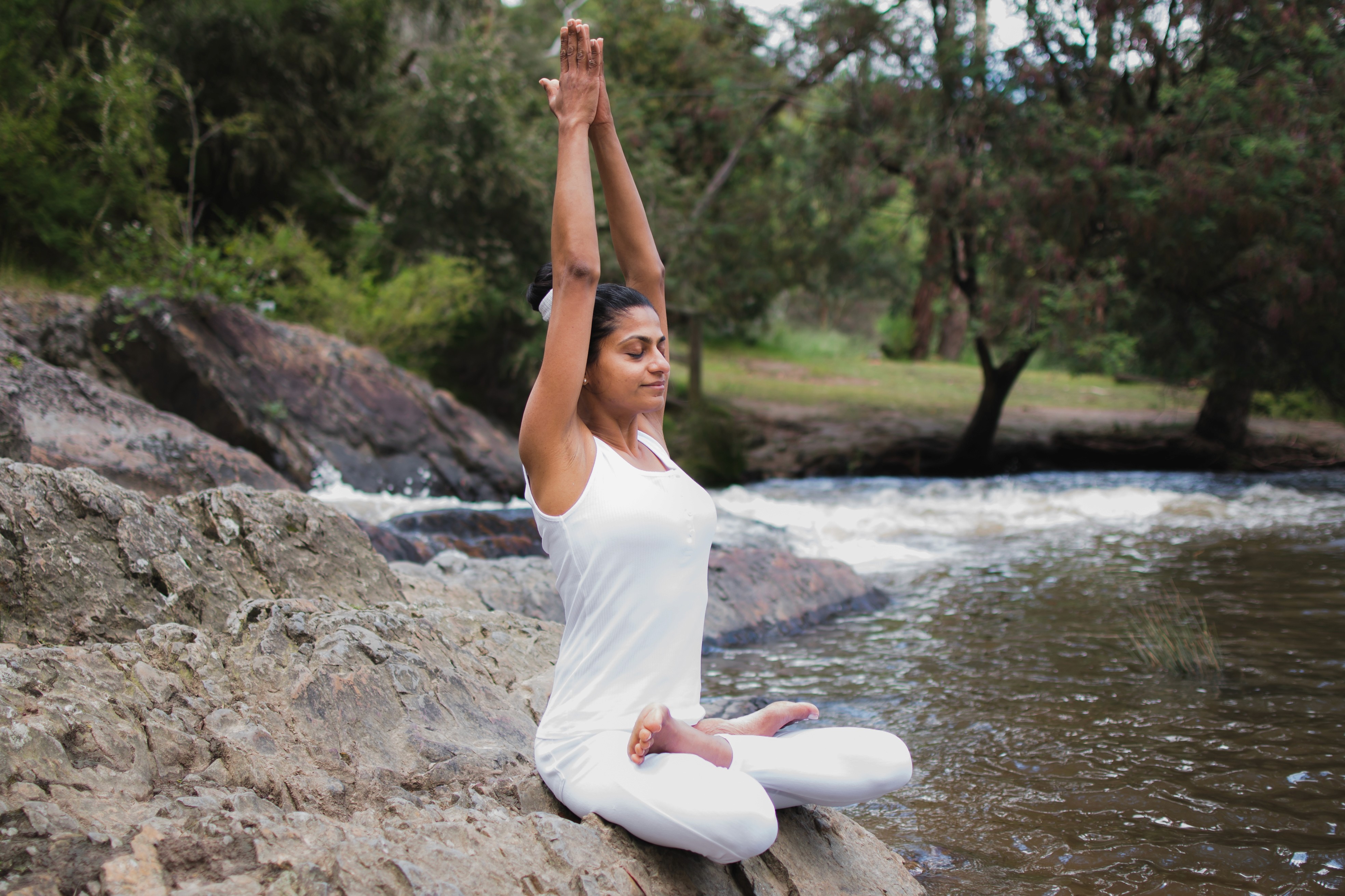 Two people doing a side stretch pose on yoga mats