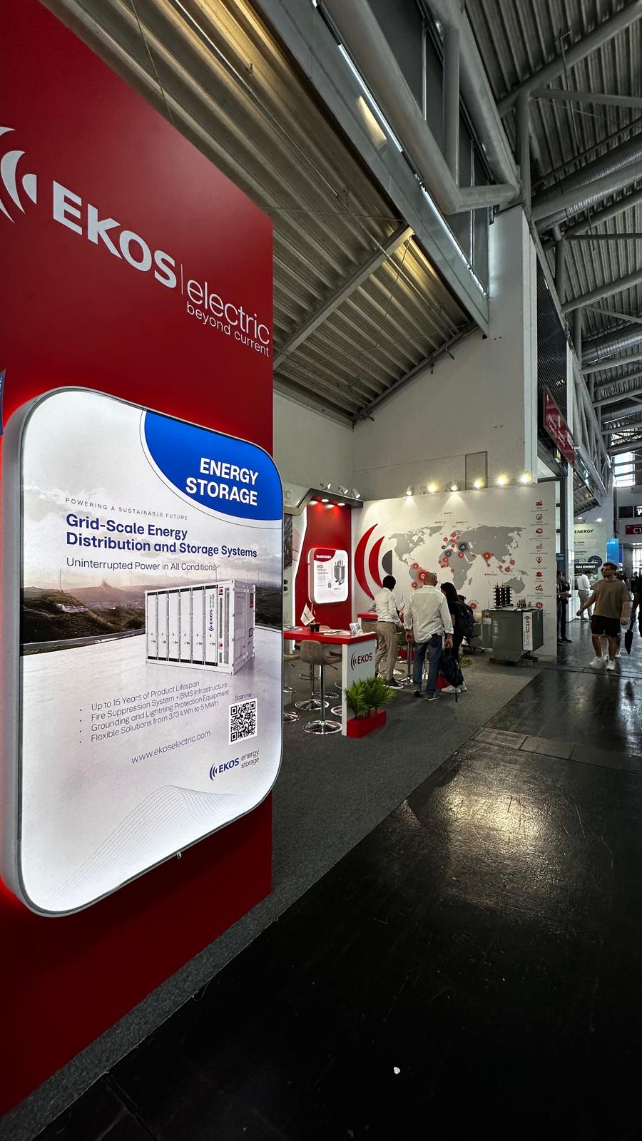 Curved lightbox panels at the EKOS Electric stand, reinforcing the wave‑like design language and brand identity.