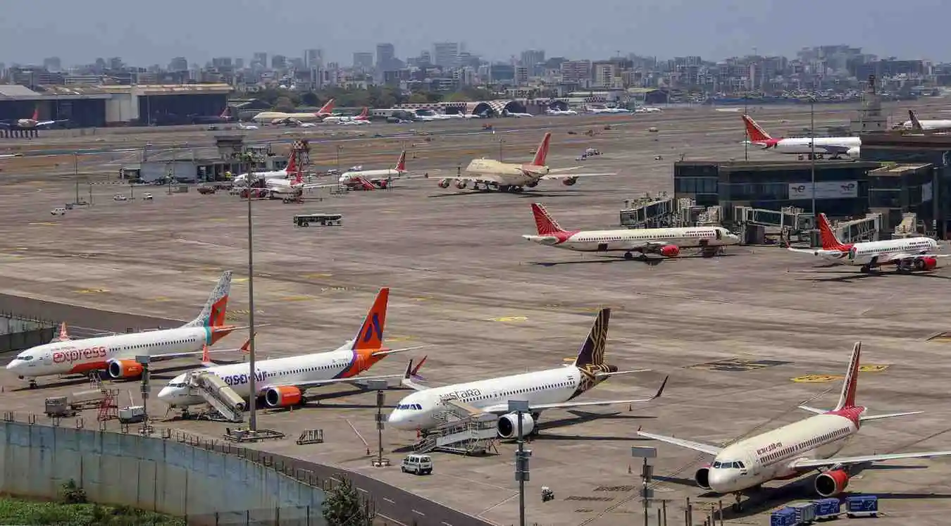 <img src="chipi-airport.jpg" alt="Airplanes parked at a busy Chipi Airport taxiway on a sunny day, with airport buildings and the city skyline in the background." />