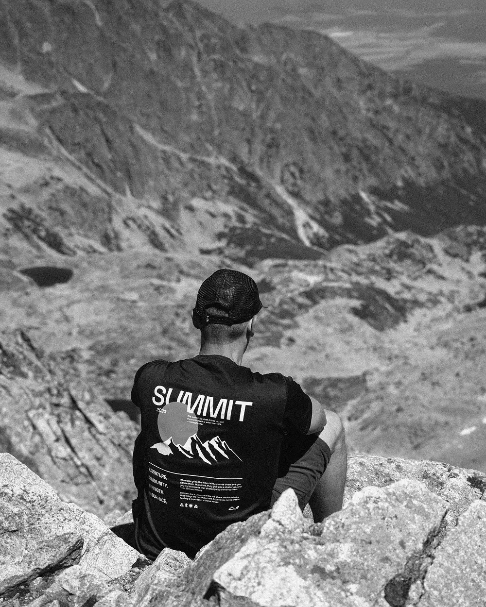 Summit sportoló csapatpólóban ül a Magas-Tátrán