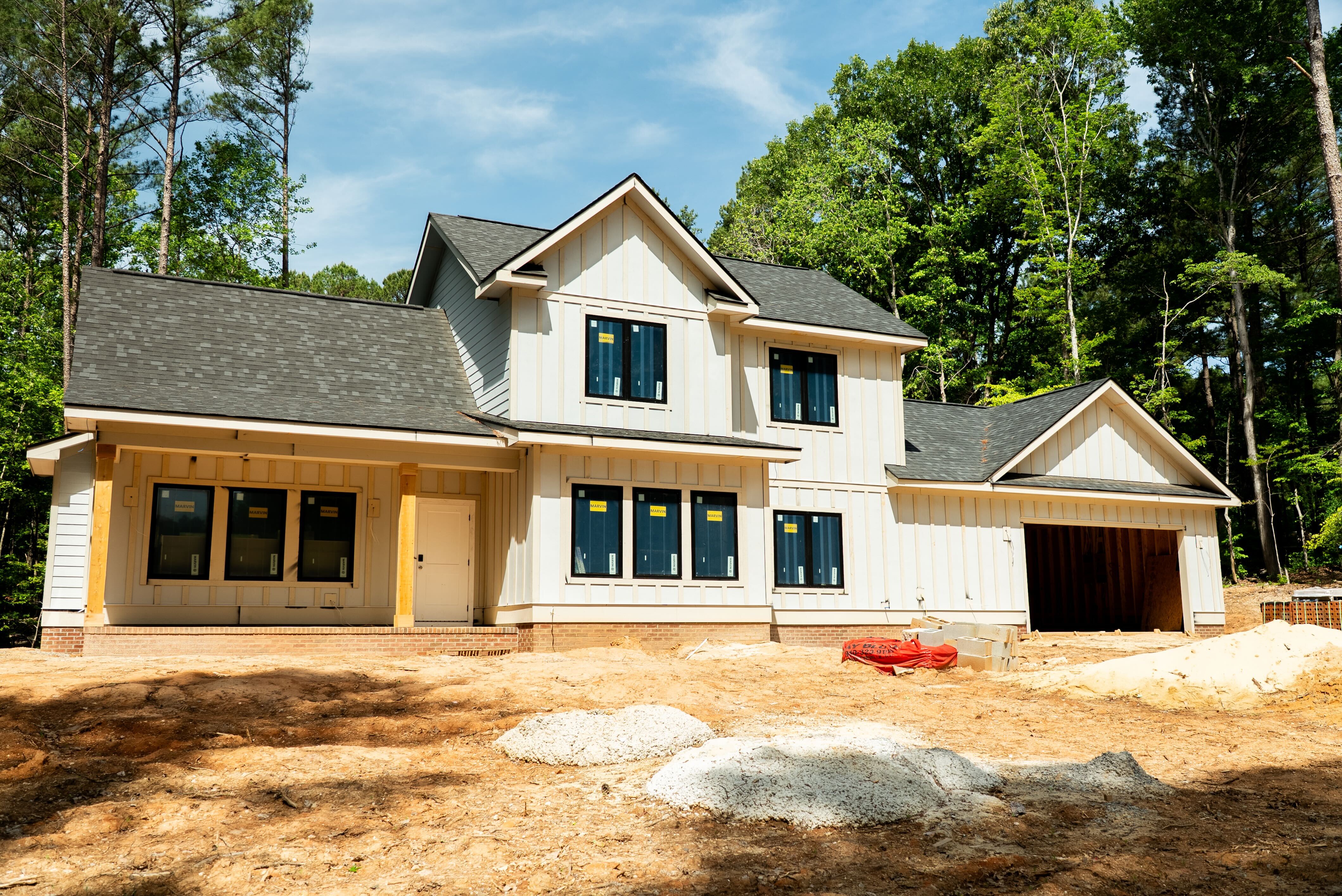 Beautiful custom home under construction in North Carolina with white board-and-batten siding and dark roof