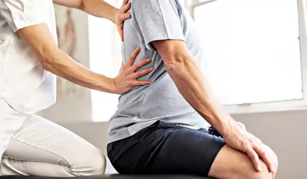 Physiotherapist providing manual spinal therapy to improve posture and relieve back pain.