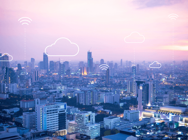 City skyline at sunset with digital cloud and Wi-Fi icons overlayed, symbolizing connected software systems for public safety and emergency operations.