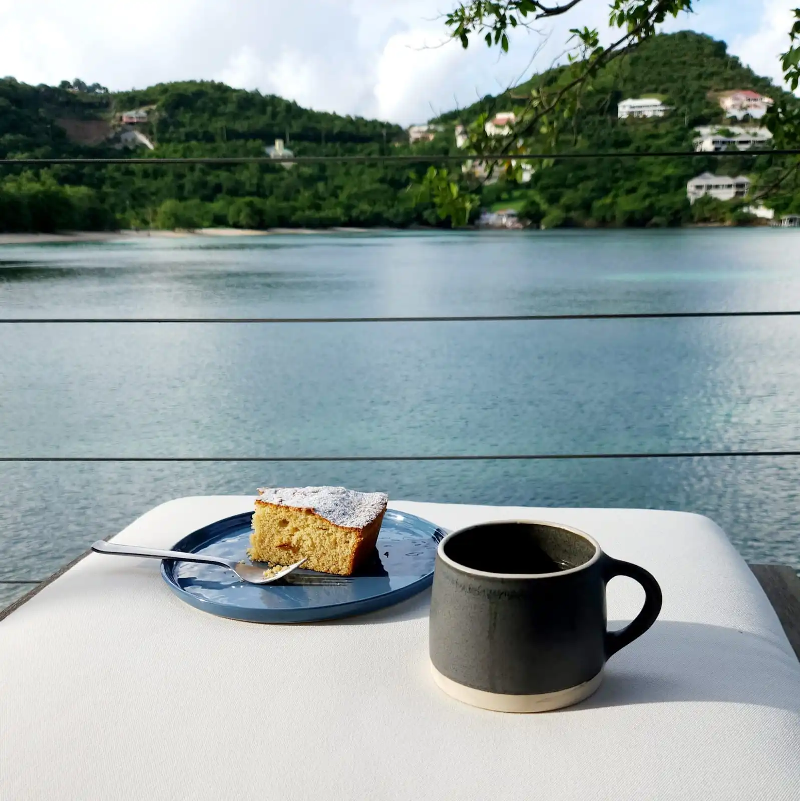 Outdoor dining terrace with panoramic bay views at waterfront residence in St. Lucia