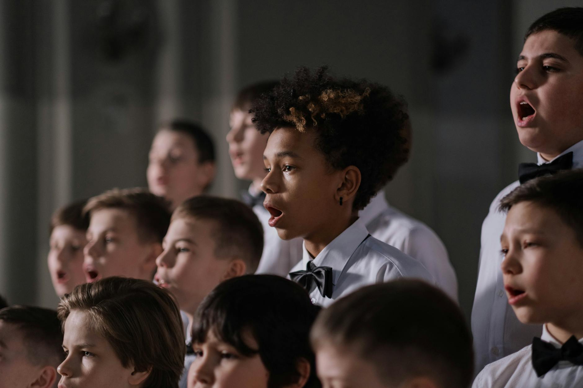 An elementary teacher using hand signs and colorful posters to lead a group of young children in a rhythmic song.