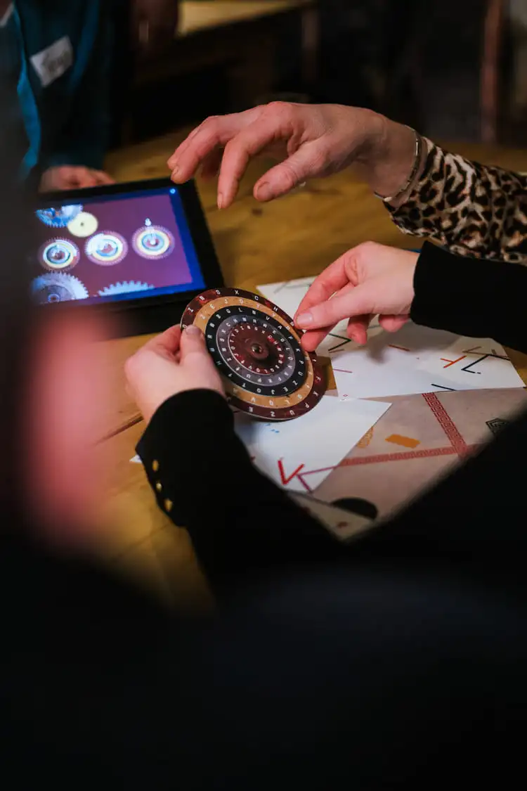 Deelnemer draait aan een letterschijf tijdens een teambuilding activiteit van The Box Company