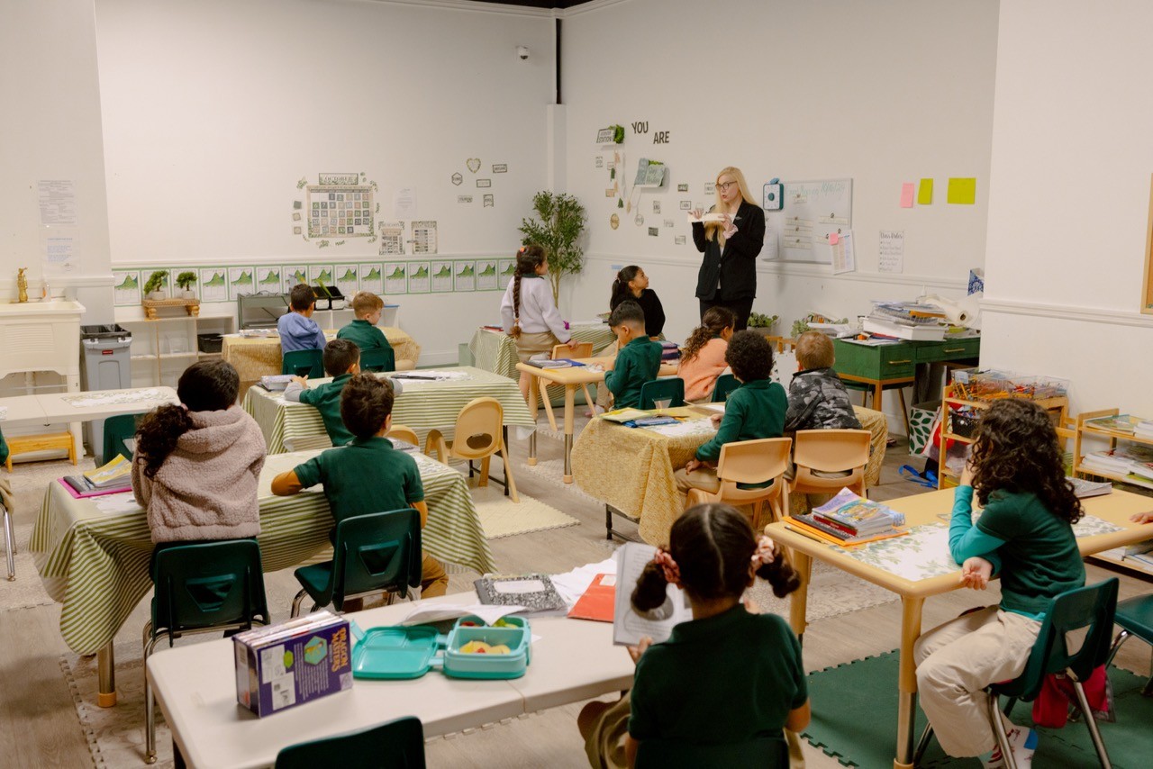 A classroom of children focused on a teacher reading