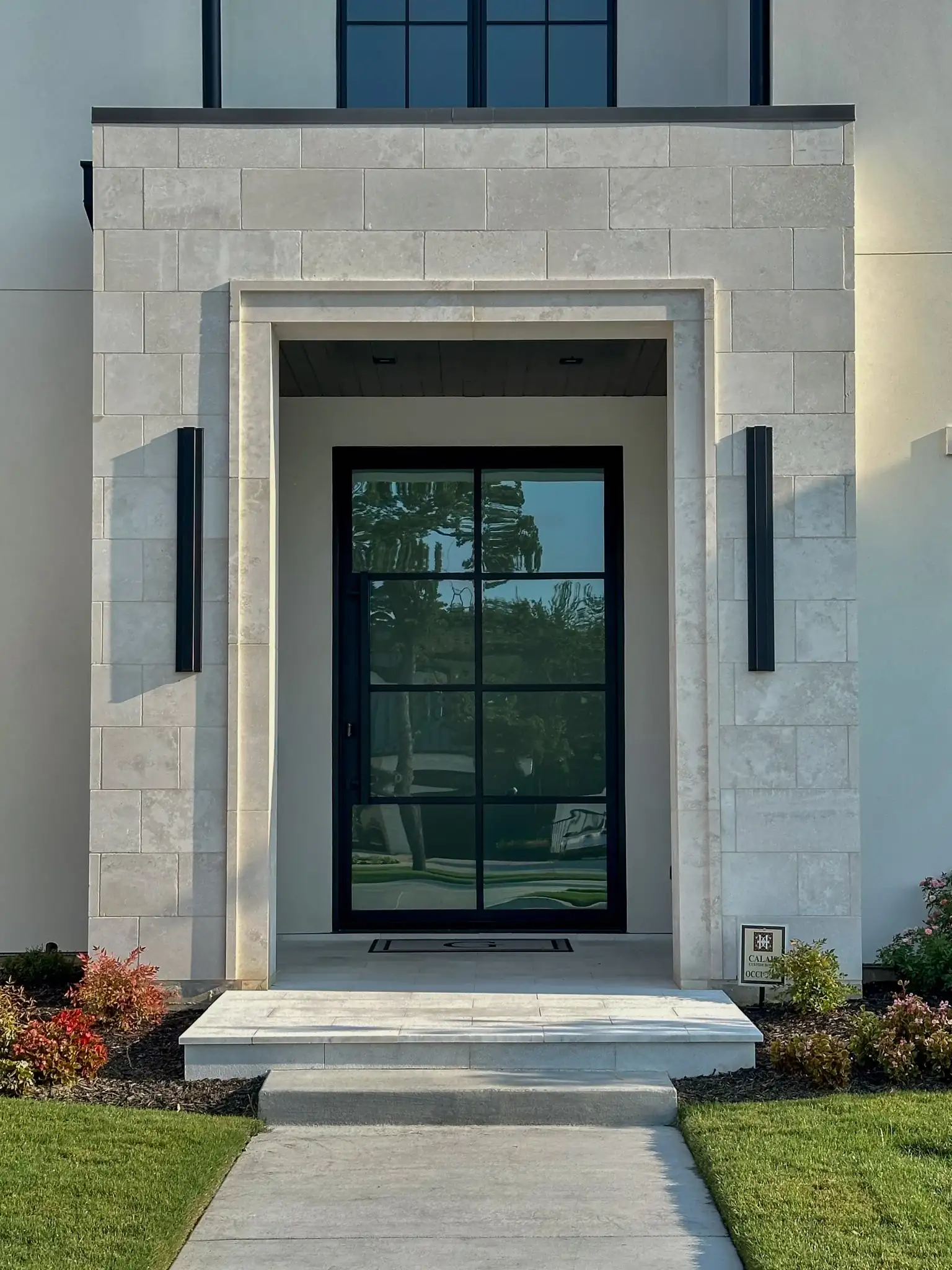 Modern entryway with a steel grid style pivot door