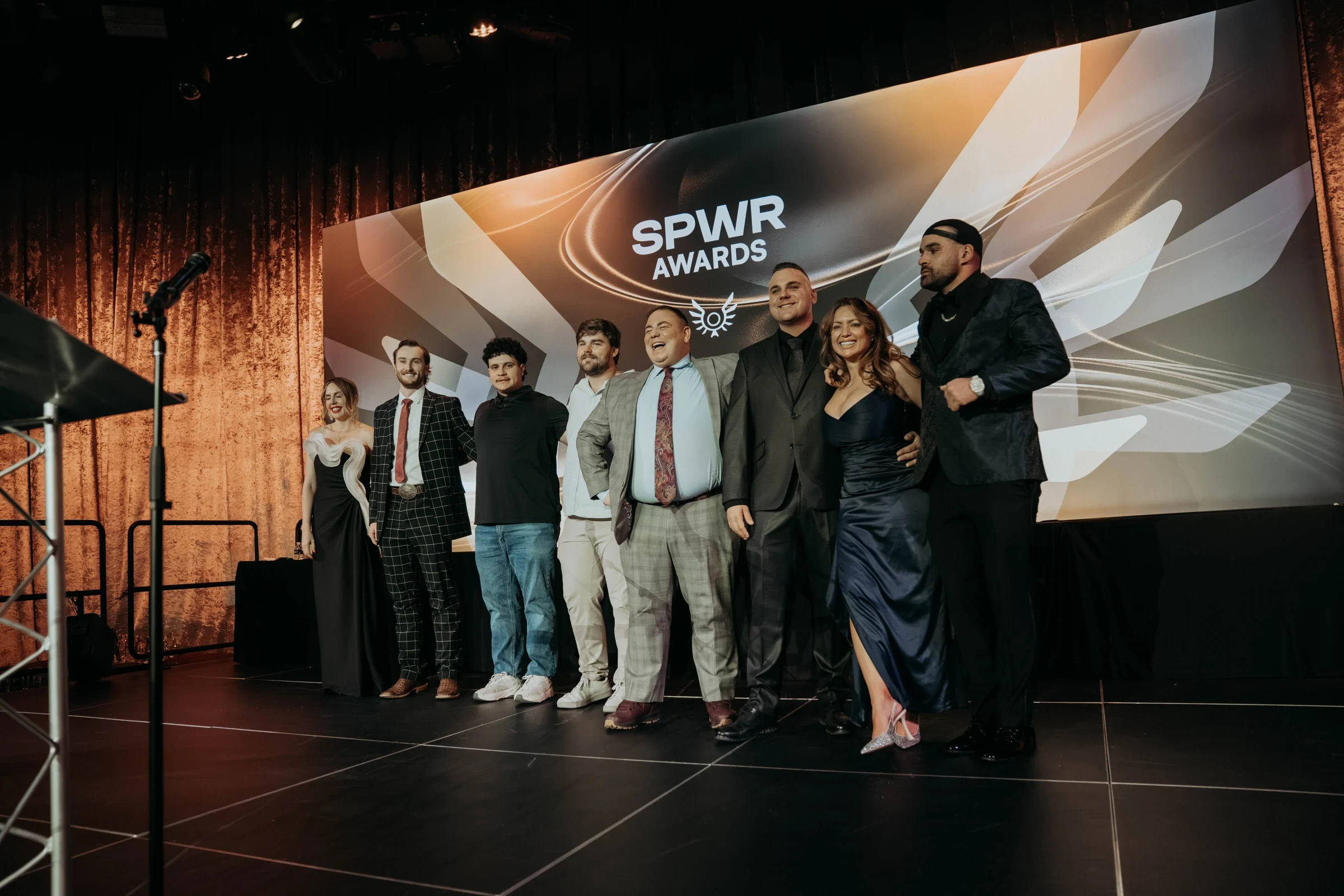Award recipients on stage in front of the SPWR Awards event graphic