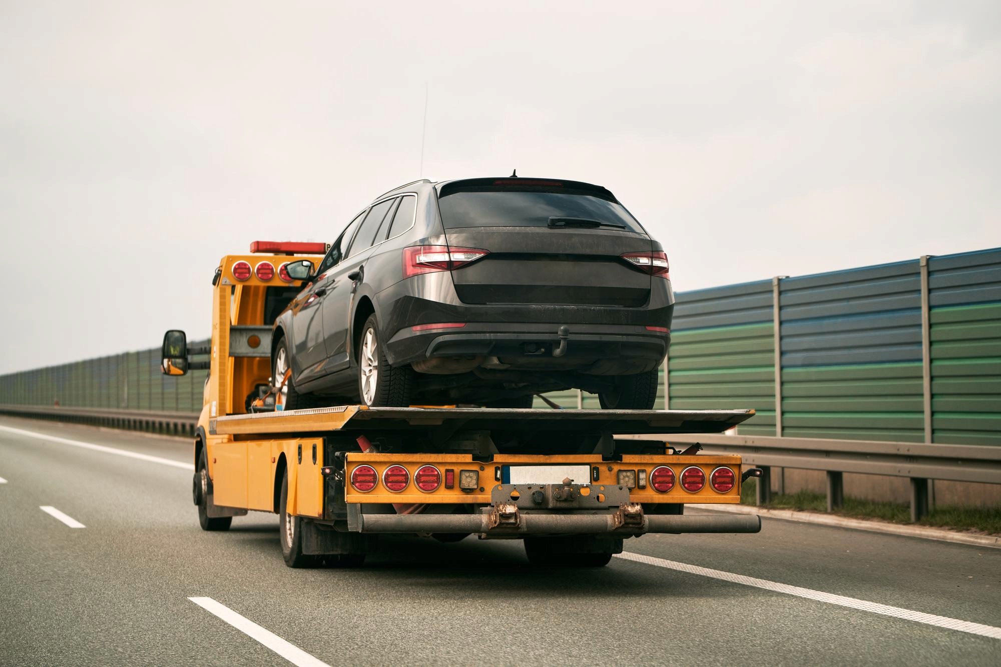 Ein Auto wird auf der Ladefläche eines Tiefladers transportiert