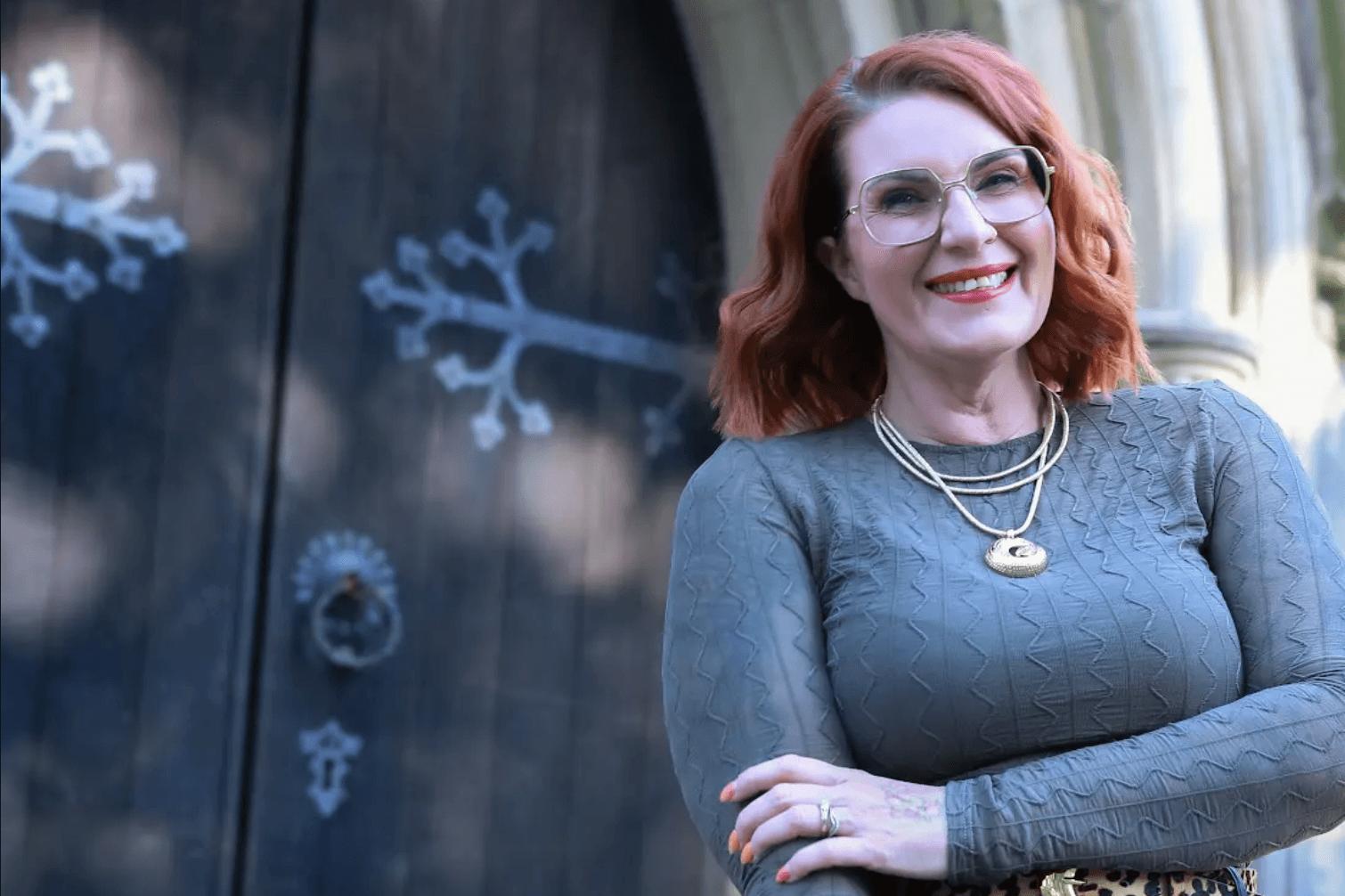 woman in blue tank top standing beside white wall